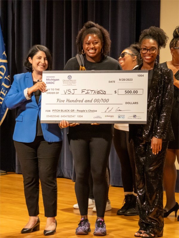 Valarie James accepts her $500 cash prize for receiving the People's Choice Award during the 2023 Pitch Black Competition.