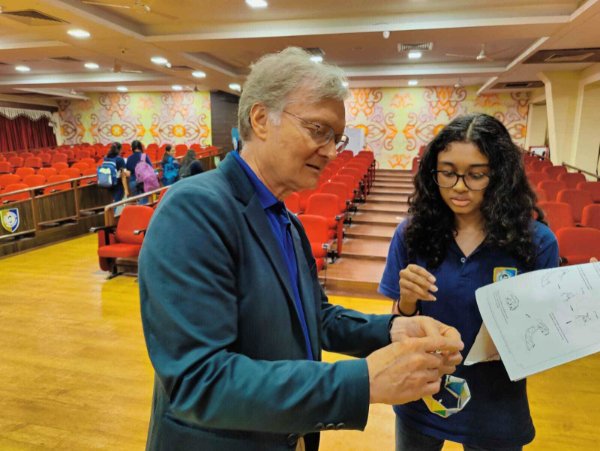 Mark Staves shows a DNA paper to a student in India