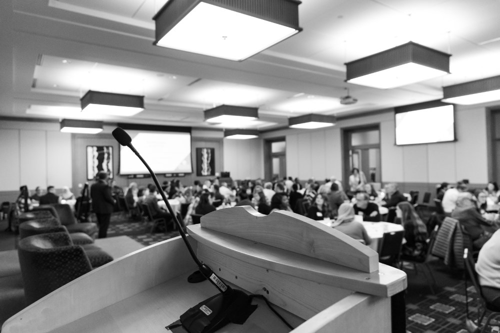 black and white photo of a microphone and podium at an event