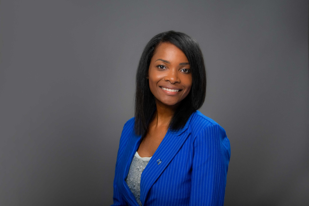 Candace Phenix portrait in blue jacket against gray background