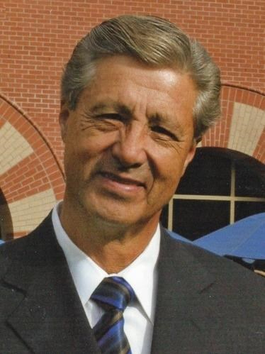 Antonio Herrera standing outside the DeVos Center in a suit and white shirt and striped tie