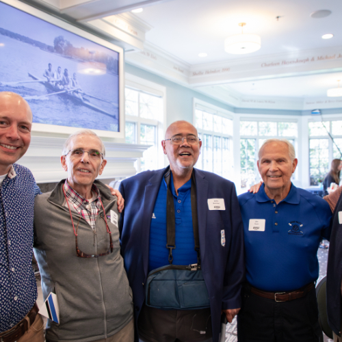 five people stand in a row in the Alumni House