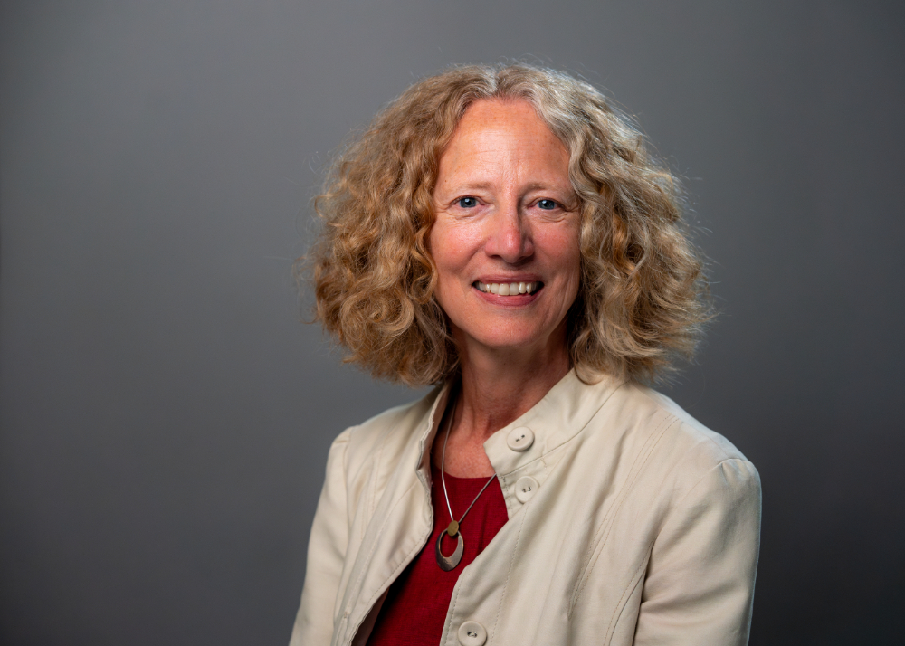 Jennifer Drake in light jacket and maroon shirt in studio portrait