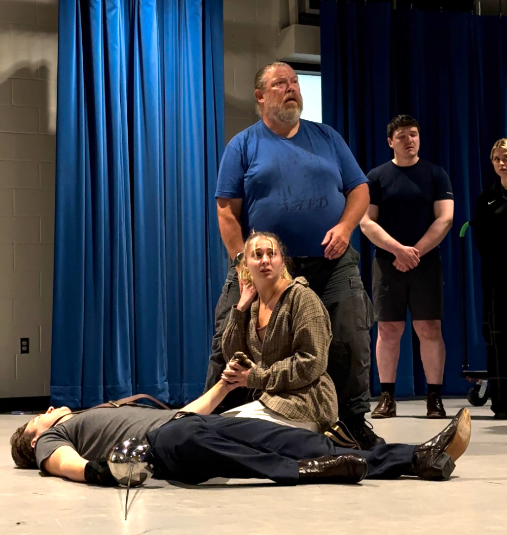 four people on stage, one lying on floor during scene in Romeo and Juliet