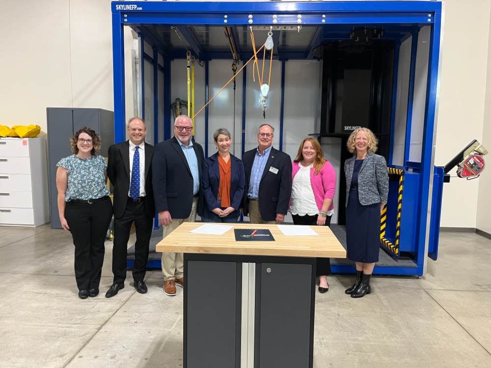 seven people standing in front of industrial lift