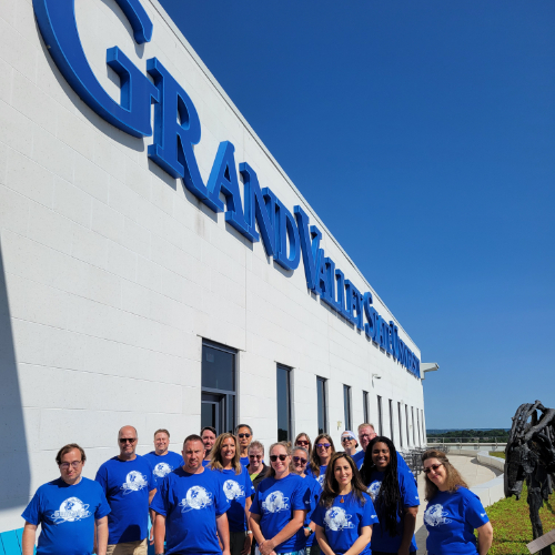 group of people standing on balcony of DCIH with GVSU lettering at top of buidling wall