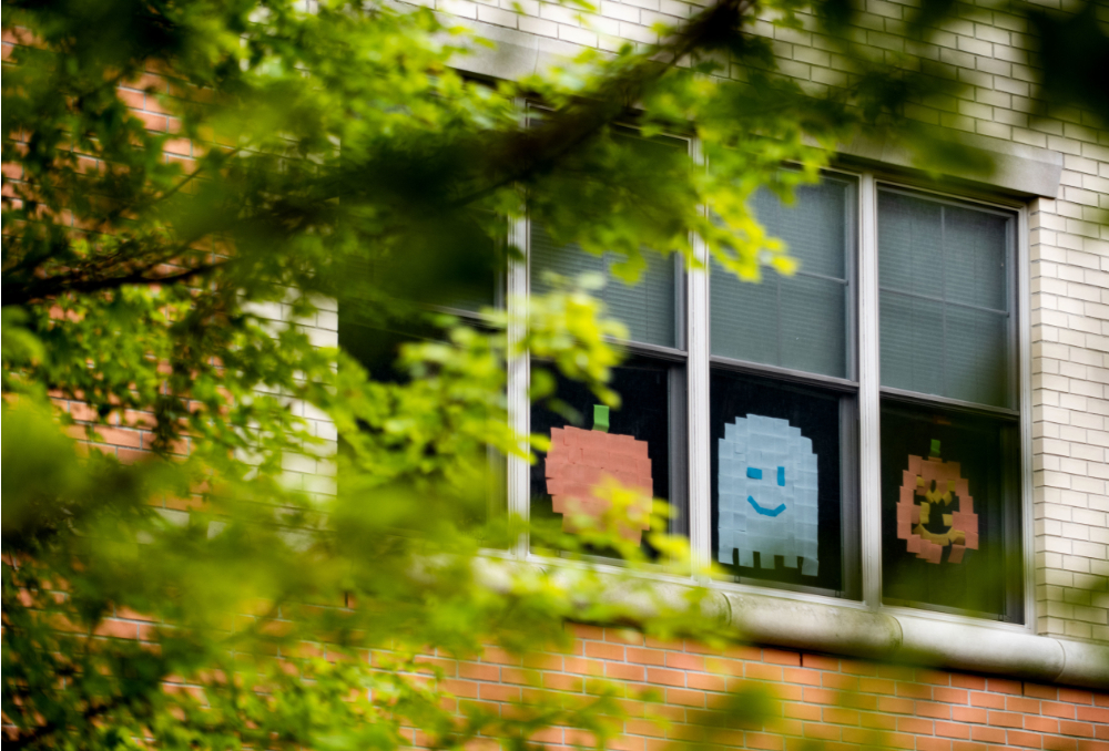 windows in living center decorated with pumpkin and smiling ghost