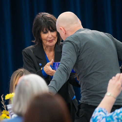 President Mantella presents a gift to man who stands from a table of people to accept it