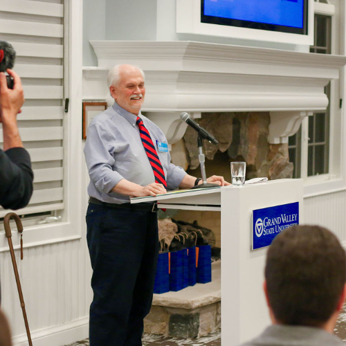 Alex Nesteranko behind podium at the Alumni House