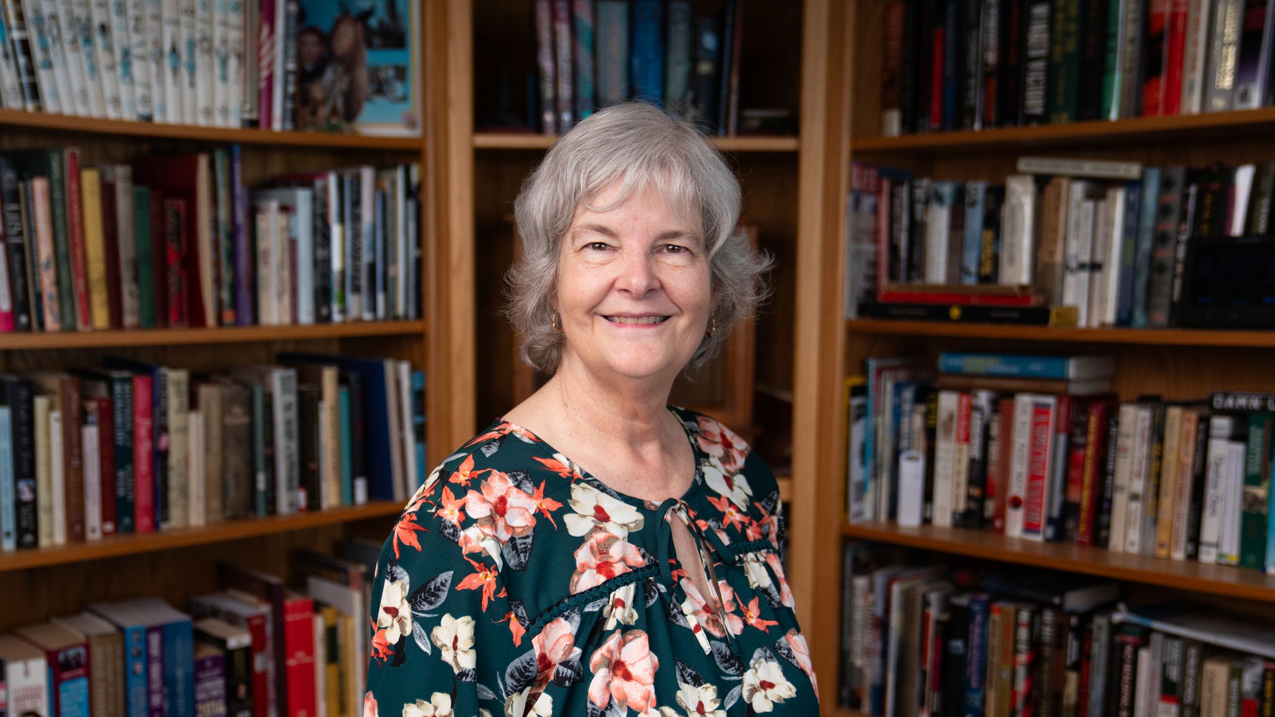 Alison McManus Walters stands in front of bookcases