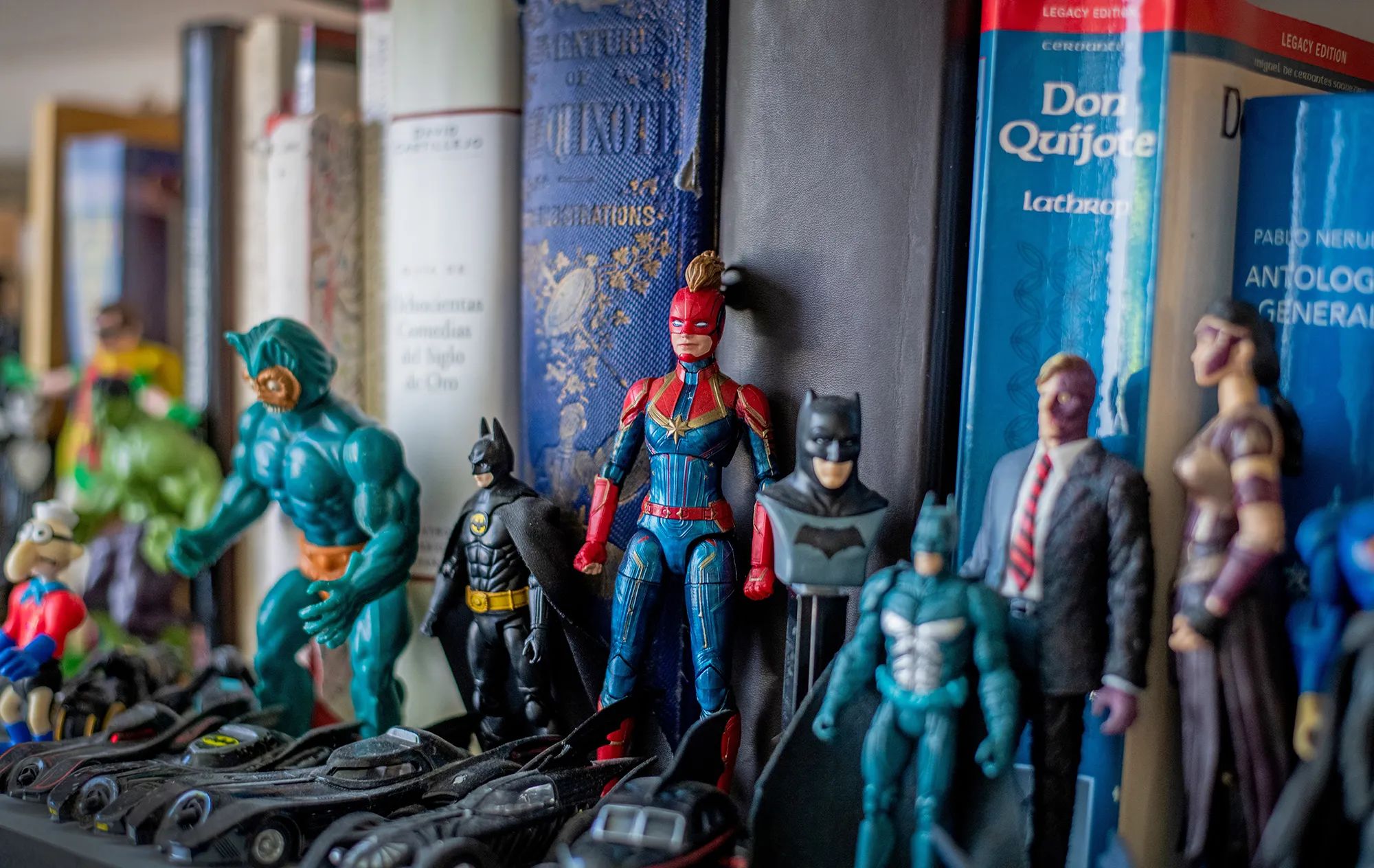 Superhero and villain figurines sit on a bookshelf