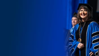 President Mantella in academic regalia standing with smile