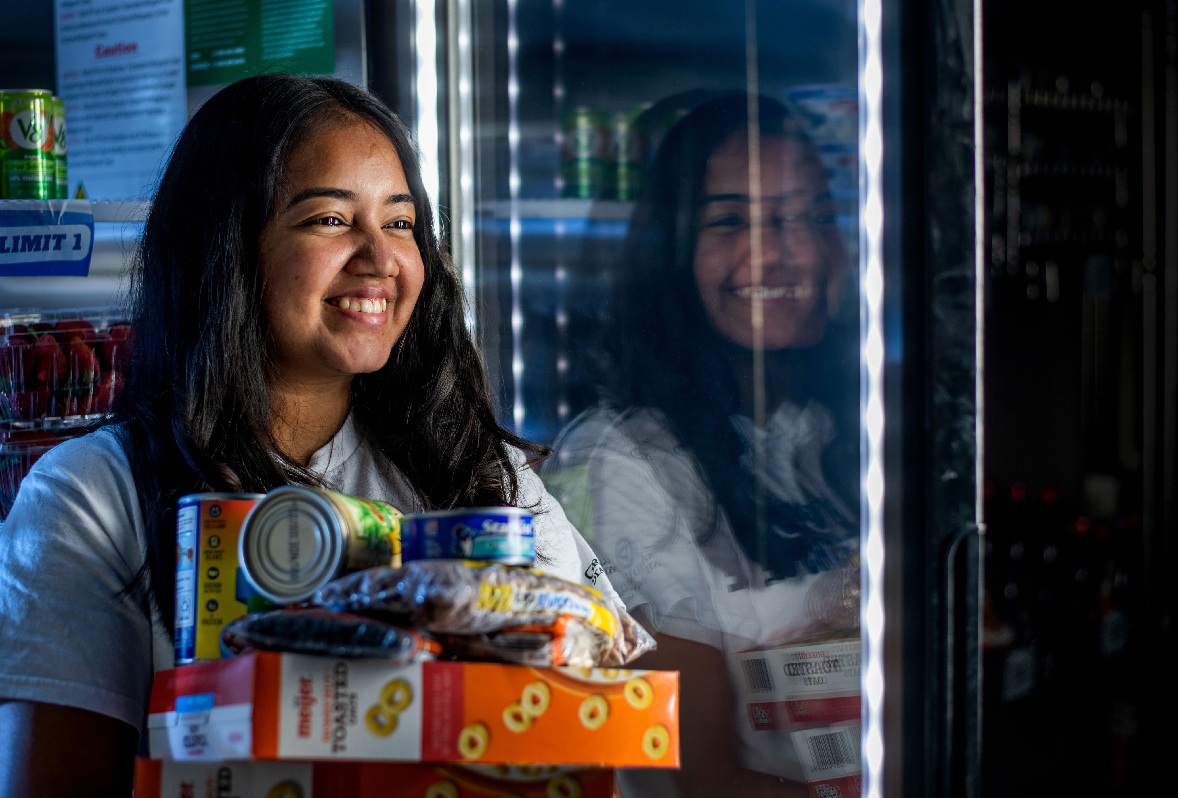 Priyan Maddela holds groceries in her arms in the Replenish pantry in Kirkhof Center.