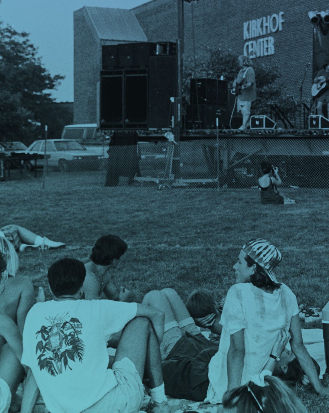 crowd seated on grass outside Kirkhof Center for a concert