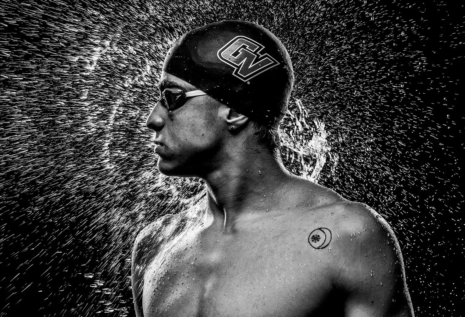 Swimmer with swim cap, water spraying off him