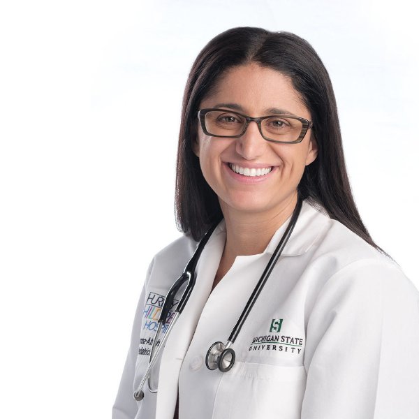 headshot: Dr. Mona Hanna-Attisha in white coat with stethoscope around neck