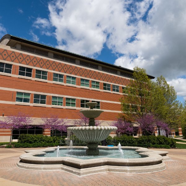 Padnos Hall photo with blue sky, clouds and fountain