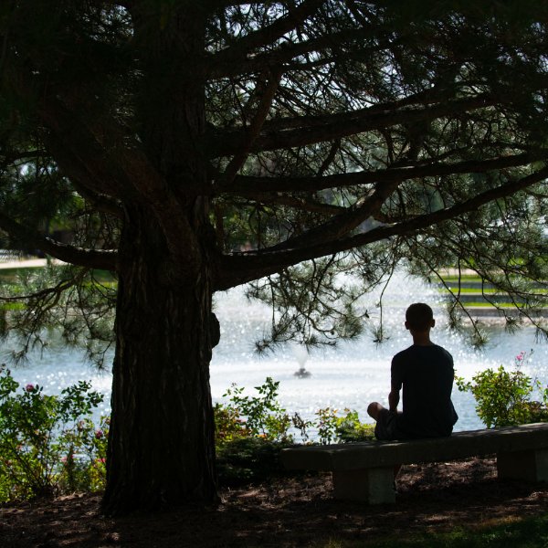 A G-V-S-U student sits by the Zumberge Pond on the Allendale Campus.
