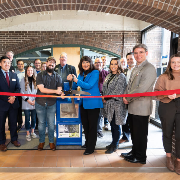 Grand Valley Lanthorn staff, President Philomena V. Mantella and community members celebrate the newspaper's 100th distribution site at a ribbon-cutting ceremony in Kirkhof Center on the Allendale Campus January 31.