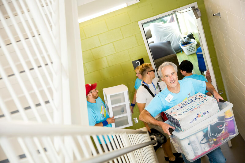 Dan Hartlieb joins other alumni to help first-year students move into their living centers.