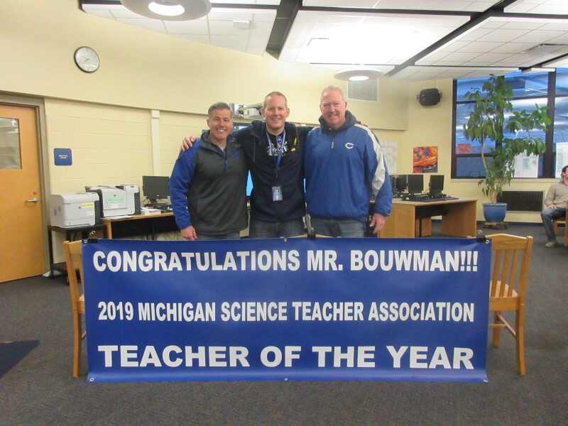 Jeff Bouwman, '03, (center) has been named the 2019 Middle School Science Teacher of the Year by the Michigan Science Teachers Association.