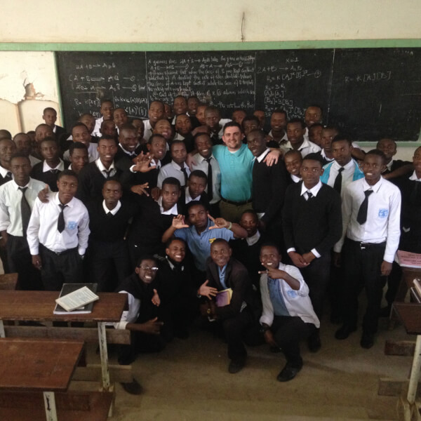 Roy Herpin stands with a group of students at a school in Tanzania.