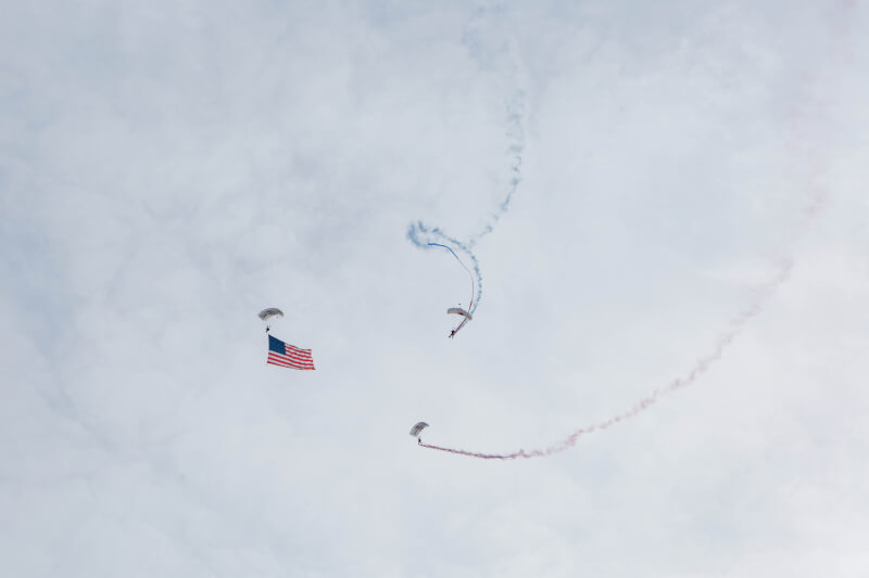  Three parachuters in the sky with an American flag
