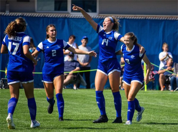 Members of the women's soccer team celebrate a play. 