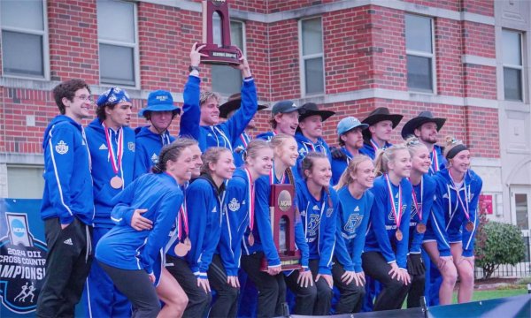 The men's and women's cross country teams pose with their trophies after winning NCAA Regional Championships. 