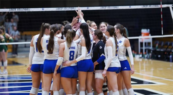 Members of the volleyball team circle up at start of a match.