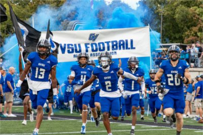 GVSU football team runs on to Lubbers Stadium field at start of game.