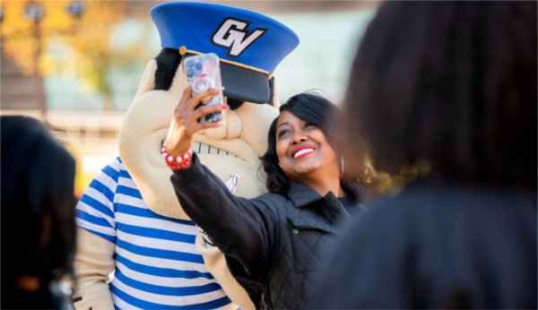  A person takes a selfie with Louie The Laker.