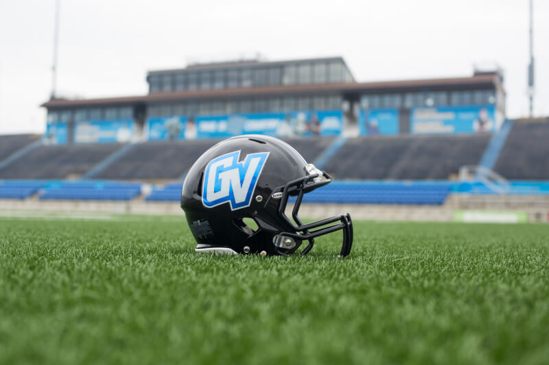 A Grand Valley football helmet sitting on the turf at Lubbers Stadium.