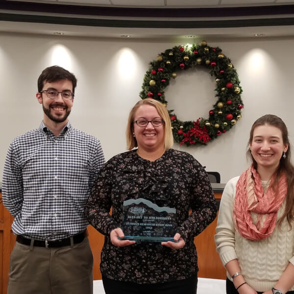 Lab manager Michael Hassett, research assistant Maggie Oudsema, and graduate student Emily Kindervater accept the watershed award from the Macatawa Area Coordinating Council.