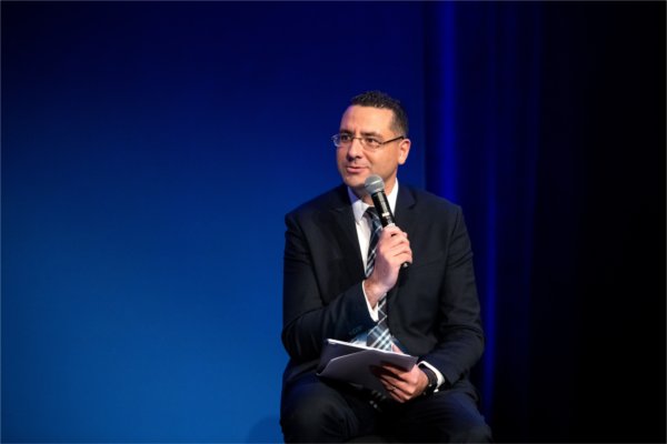 College of Computing Dean Marouane Kessentini asks a question to President Philomena V. Mantella and former Ford and Steelcase CEO Jim Hackett. 