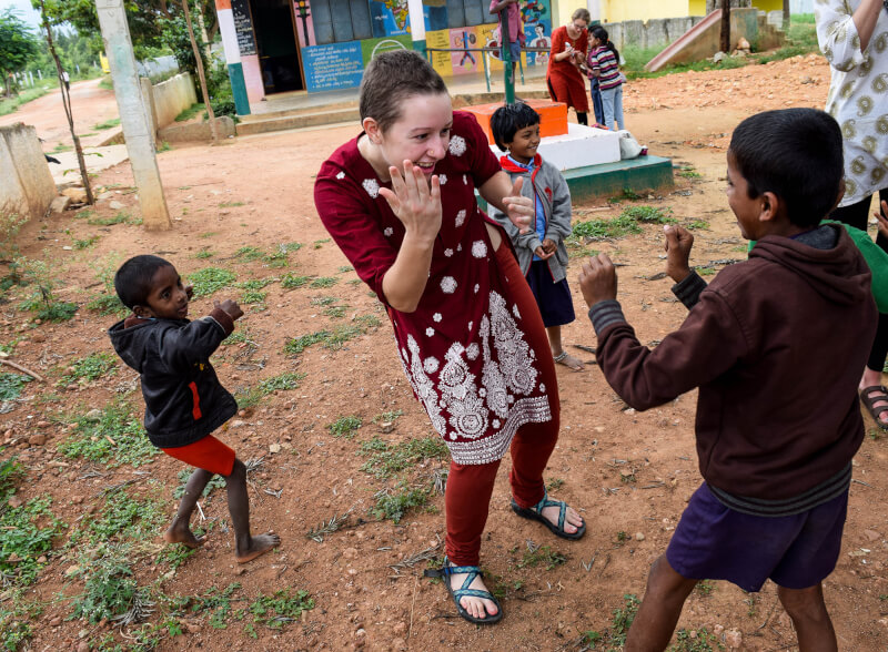 woman dancing with child in colorful clothes, India