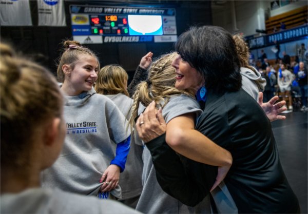 President Philomena V. Mantella hugs a wrestler following Grand Valley's dual meet against Northern Michigan.