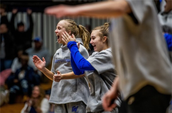 Members of the women's wrestling team cheer on a teammate during her match against Northern Michigan.