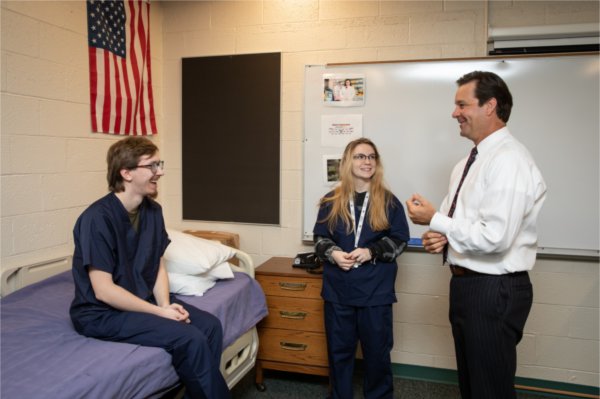 North Ed Superintendent Nick Ceglarek gets ready for a blood pressure check from Owen Turick and Athena Dewey, students from the health sciences program at Northwest Education Services (North Ed) Career Tech. GVSU has expanded its direct credit partnerships with state tech centers.