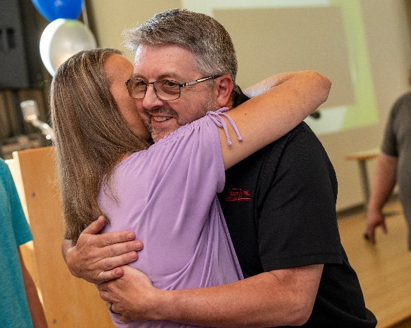 Michael Gerstweiler, owner of Pribusin Inc., hugs his wife, Sue Gerstweiler, after winning the 2024 Lakeshore Innovator of the Year award at the Muskegon Innovation Hub on July 25.