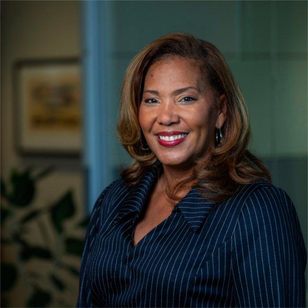 LuWanna Williams wears a navy blue pinstriped blazer and smiles.