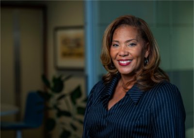 LuWanna Williams wears a navy blue pinstriped blazer and smiles.