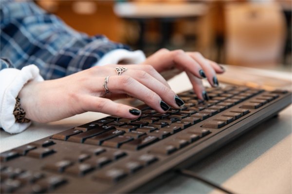 A closeup of a person typing on a keyboard.