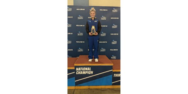 Gracyn Segard stands with a national championship trophy on a podium.