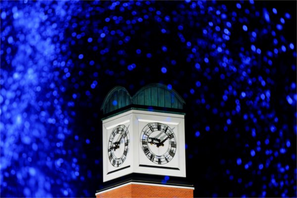 The Cook Carillon Tower is pictured through the blue lights of the Zumberge Pond fountain.