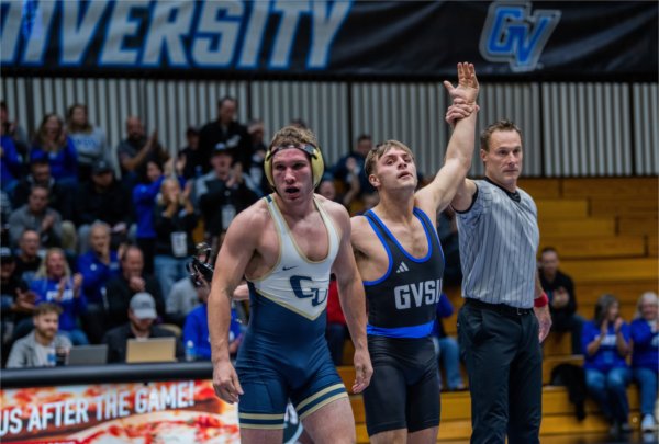 An official raises the arm of wrestler Josh Kenny following his victory over Cornerstone's Cooper Mansfield in November 2023.