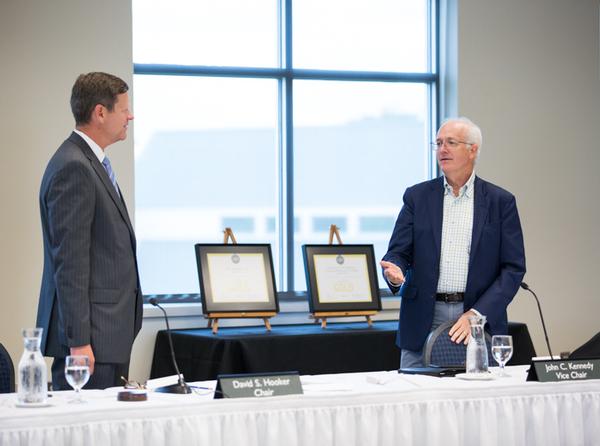 New board chair John C. Kennedy, right, expressed the board's gratitude to outgoing chair David S. Hooker.