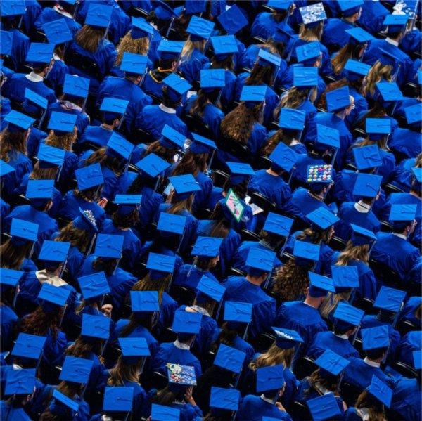 A large group of people wearing blue graduation caps.