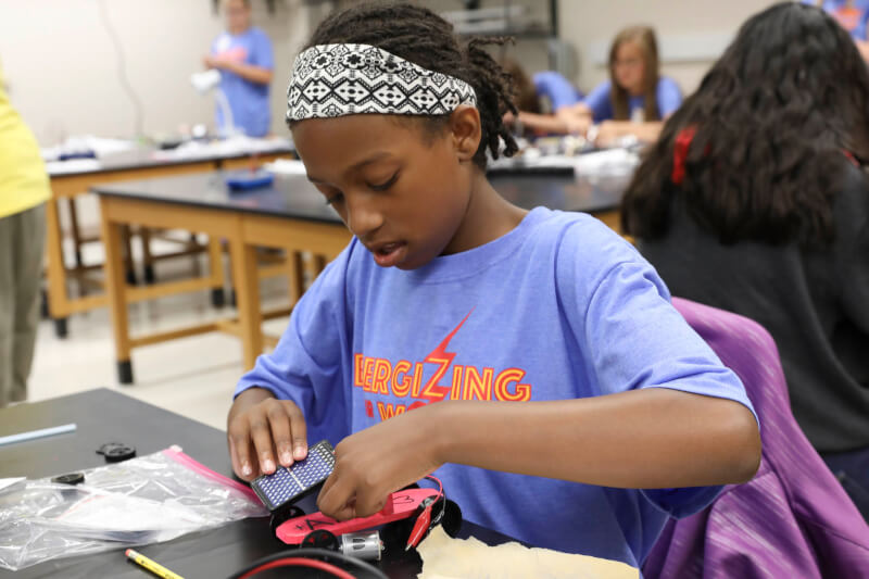 Campers building solar-powered cars during an interactive session.