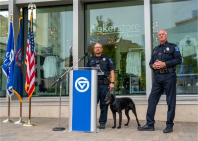 GVPD Chief Brandon DeHaan, right, and Officer Paul Weaver, stand with Scout, the new black Labrador K9 police dog, during a press conference.